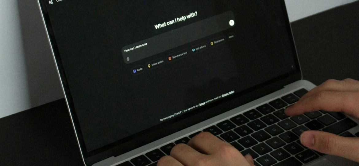 Persona escribiendo una consulta a un asistente de inteligencia artificial en el portátil