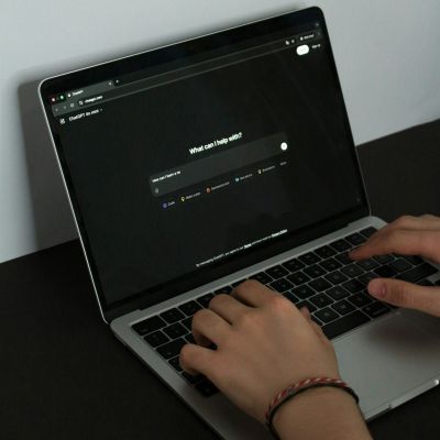 Persona escribiendo una consulta a un asistente de inteligencia artificial en el portátil