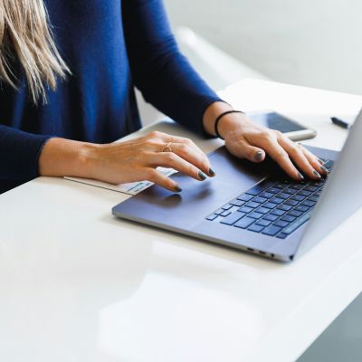 Empresaria revisando el presupuesto de SEO de su negocio en el portátil