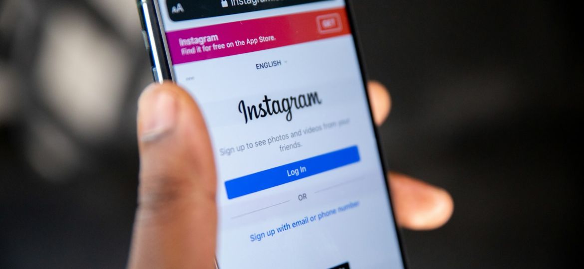 Mano sujetando un smartphone con una red social abierta